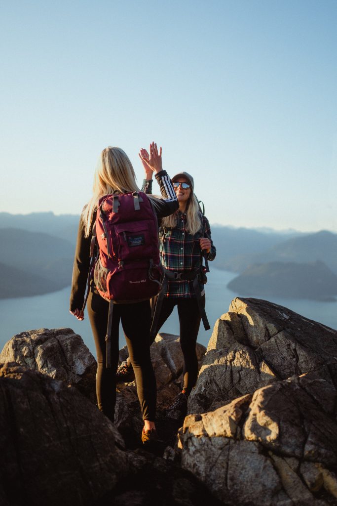 Two women hikers high fiving